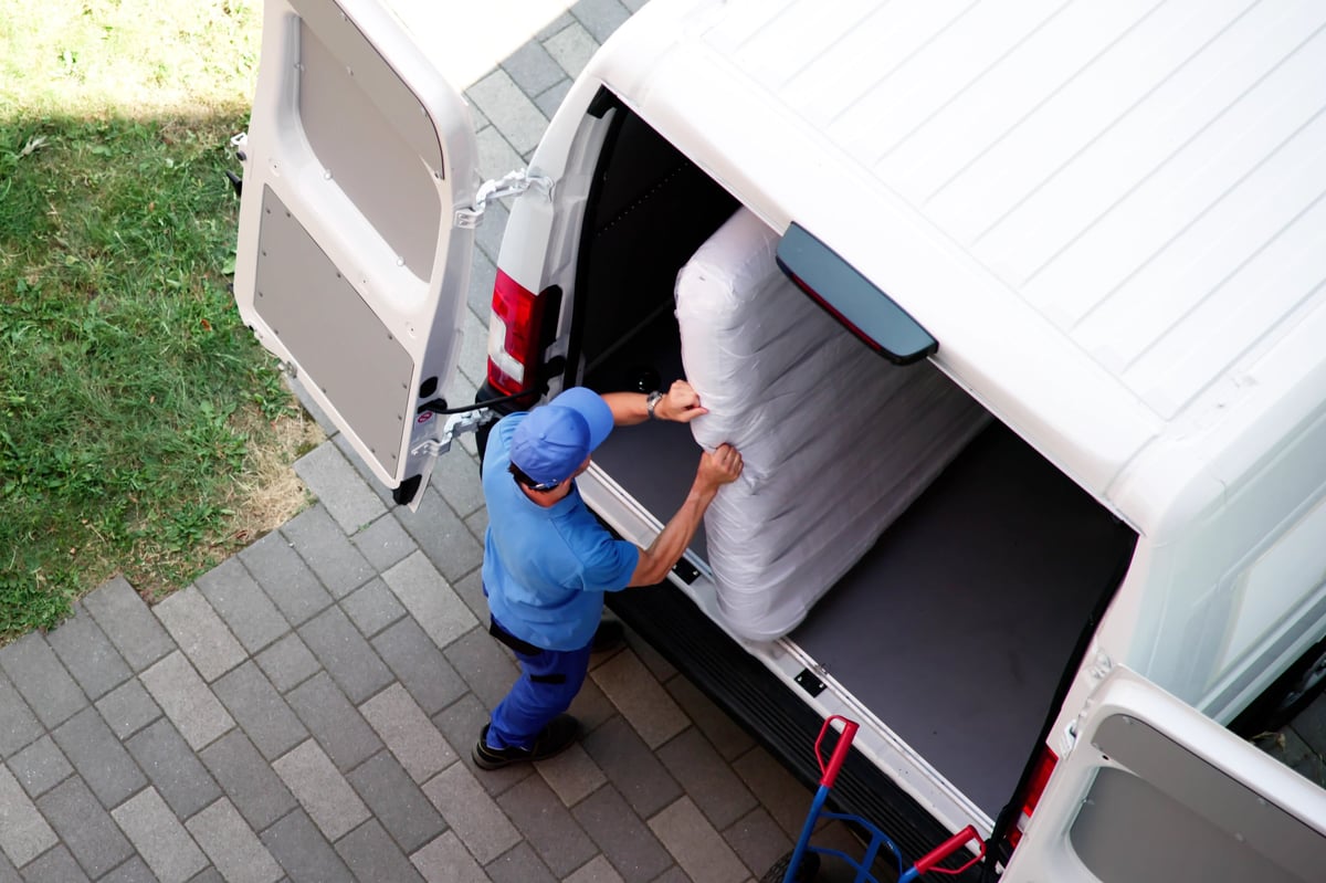 Busy Day: Mover Carrying Boxes Into New Home With Truck