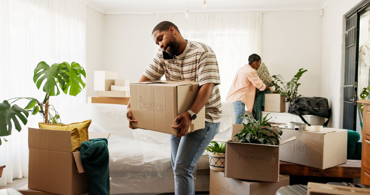 Box, phone call and real estate with black couple moving in to new home for relocation or update. Carry, conversation and property with people in apartment for mobile discussion, packing or planning